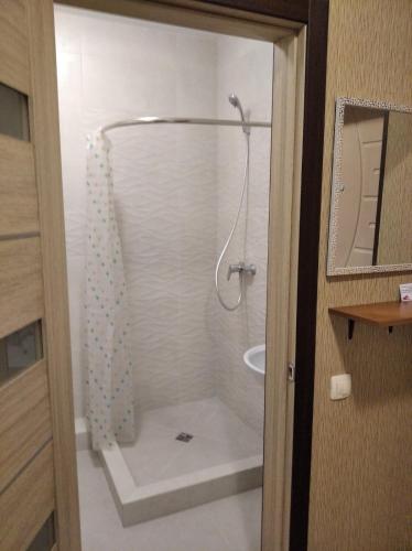 La salle de bains est pourvue d'une douche avec rideau de douche. dans l'établissement Квартира в ЖК Атриум, à Irpin