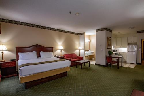 a hotel room with a bed and a kitchen at Moncks Corner Inn in Moncks Corner