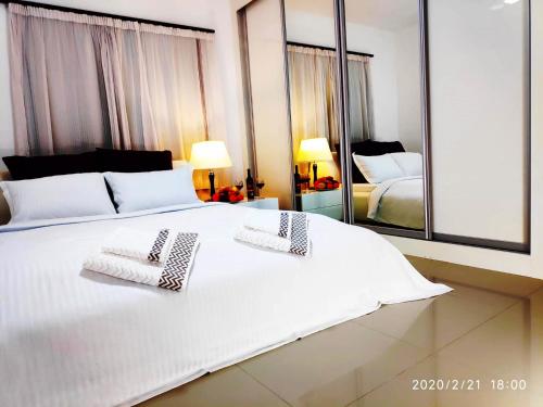 1 dormitorio con 1 cama blanca y 2 toallas en Uptown holiday app daily rental contactless Check In & Check Out en Famagusta