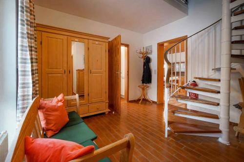 a living room with a staircase and orange pillows at Ferienhaus Bausch in Balderschwang