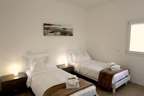 sypialnia z 2 łóżkami, 2 lampami i oknem w obiekcie DB Apartments - Dabasso w Mestre