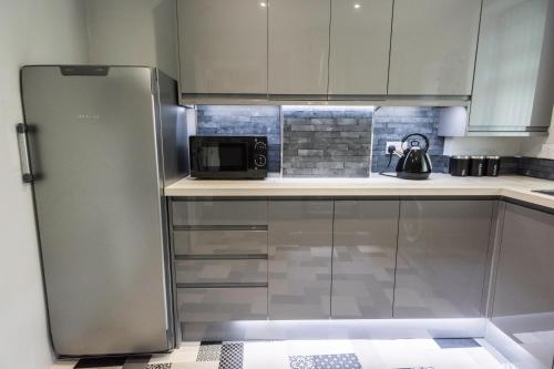 a kitchen with a refrigerator and a microwave at Spey Courtyard in Perth