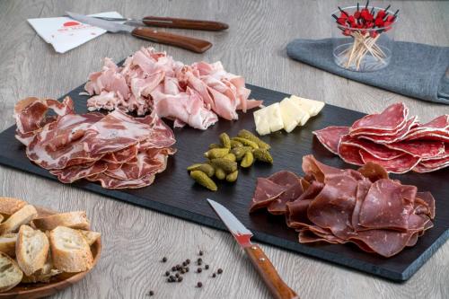 a cutting board with meats and cheese and a knife at L'Atelier - Gîte & Spa in Épernay