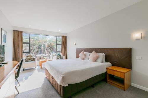 una camera con un grande letto e una grande finestra di Boulevard Hotel ad Auckland