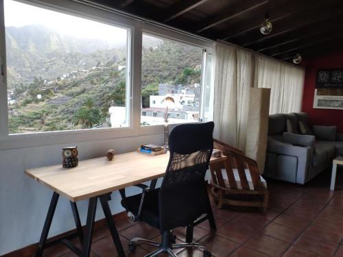 a desk and chair in a room with a window at Finca Lomo Grande in Hermigua