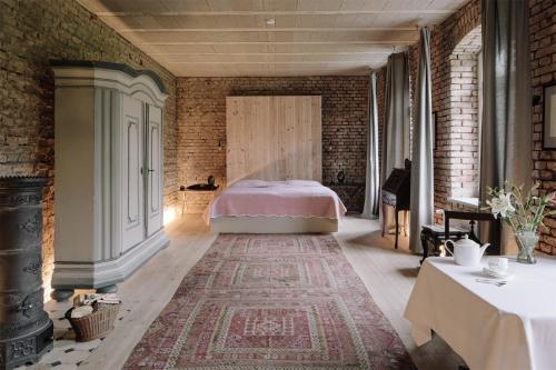 ein Schlafzimmer mit einem Bett und einer Ziegelwand in der Unterkunft Apartment im Kranich Hotel in Hessenburg