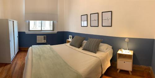 Un dormitorio con una cama con una pared de acento azul en Buenos Aires Downtown Experience #BAExp10 en Buenos Aires