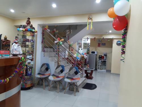 a room with a staircase with chairs and balloons at Hostal Capac in Ayacucho