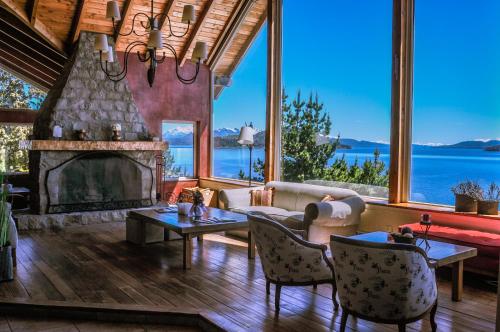 sala de estar con chimenea y ventana grande en Sol del Nahuel - Hotel & Spa en San Carlos de Bariloche