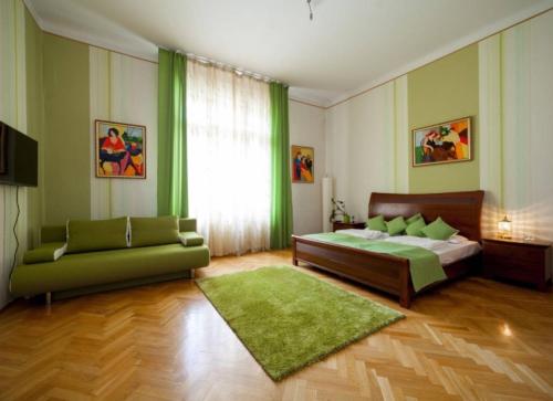 a bedroom with a bed and a green couch at Spirit Nádor Ter Apartment in Budapest