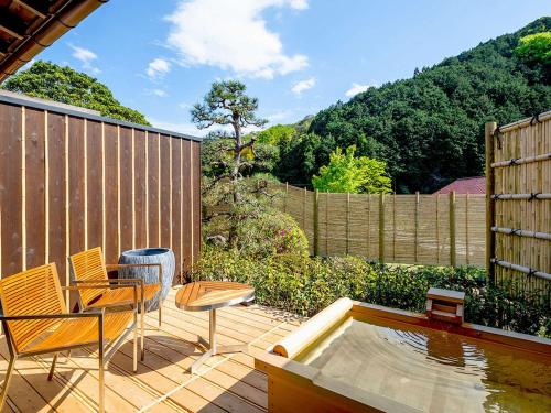 a patio with chairs and a table and a pool at Shirakabe in Izu