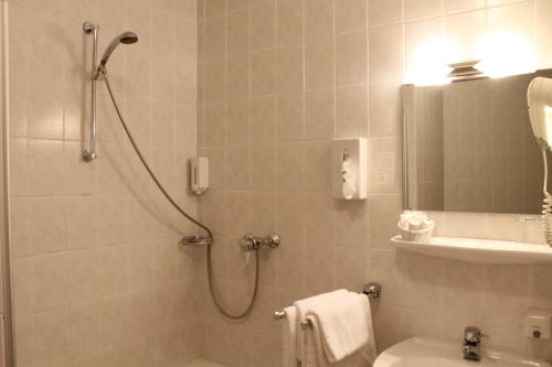 a bathroom with a shower and a toilet and a sink at City Hotel Neuwied in Neuwied