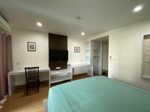 a bedroom with a bed and a tv and a chair at Teddy@Thammasart in Pathum Thani