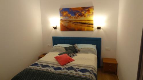 Cama pequeña en habitación con una pintura en la pared en Sarbinowo - ,,Apartament 32 u Ewy,, duży , całoroczny z Basenem, en Sarbinowo