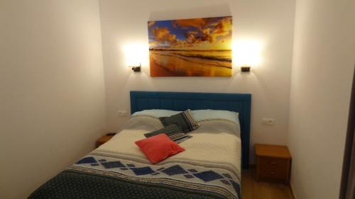 a small bed in a room with a painting on the wall at Sarbinowo - ,,Apartament 32 u Ewy,, duży , całoroczny z Basenem in Sarbinowo