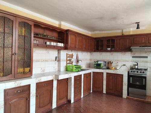 a large kitchen with wooden cabinets and appliances at Vacahouse Hostels B&B in Huaraz