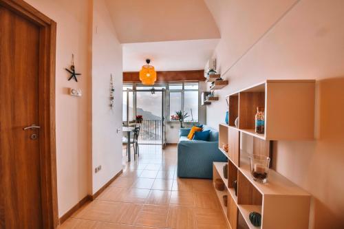 a living room with a blue couch and a hallway at CASA CHIARINA breathtaking sea view in Ravello