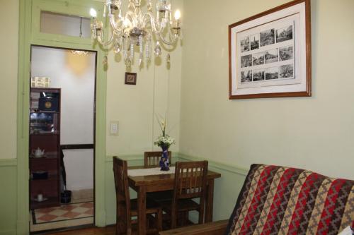 jadalnia ze stołem, krzesłami i żyrandolem w obiekcie Apartment Castillo w BuenosAires