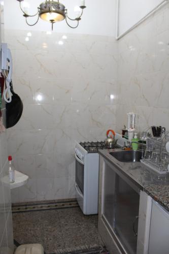 a kitchen with a sink and a stove top oven at Apartment Castillo in Buenos Aires
