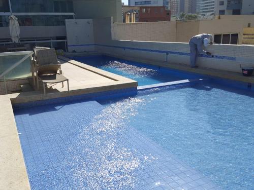 una piscina en la parte superior de un edificio en 1/4 MOBILIADO EM FRENTE À PRAIA, EM SALVADOR BAHIA, en Salvador