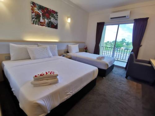 a hotel room with two beds and a balcony at SERDANG LAKE VIEW RESORT in Sungai Kechil