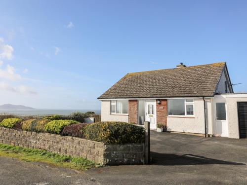 a white house with a fence in front of it at Yr Orsedd in Holyhead