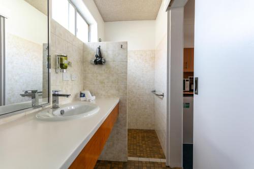 a bathroom with a sink and a mirror at Hunter Valley Motel in Cessnock