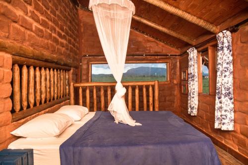 um quarto com uma cama num chalé de madeira em Raizando Ecologia Humana em Alto Paraíso de Goiás