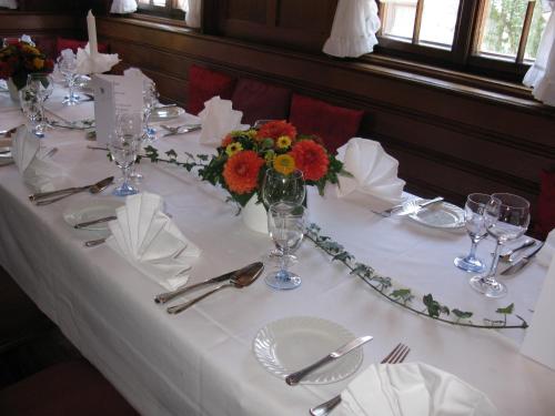a table with a white table cloth and flowers on it at Gasthaus Sonne in Vörstetten