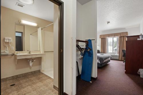 una habitación de hotel con una cama y un baño en Stay USA Hotel and Suites, en Hot Springs