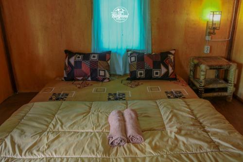 a bed with two pairs of towels on it at Pondok rinjani bungalow tetebatu in Tetebatu