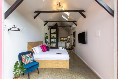 a bedroom with a bed and a blue chair at Nowra Studio Barn in Nowra