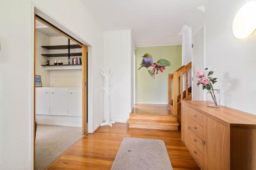 a living room with a wooden dresser and a hallway at The Bird House - Kawaha Point, Rotorua. Stylish six bedroom home with space, views and relaxed atmosphere in Rotorua