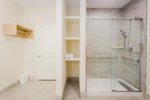 a shower with a glass door in a bathroom at Palace Inn Blue Federal Road in Houston