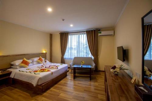 una habitación de hotel con una cama grande y una silla en Acacia Hotel Bagan, en Bagan