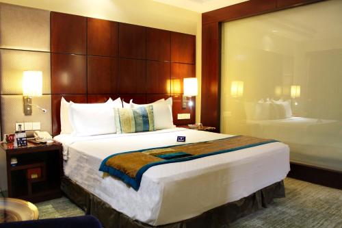 a hotel room with a large bed and a bathroom at SkyCity Hotel Gurgaon in Gurgaon