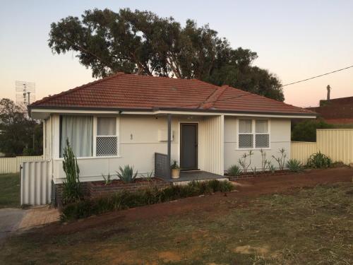a white house with a brown roof at Quick Stroll To The City in Geraldton