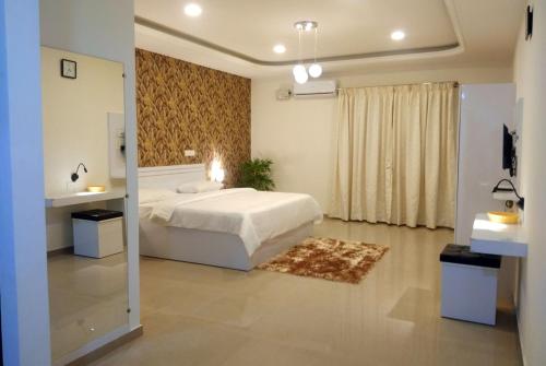 1 dormitorio con cama blanca y baño en RK - Inn Premium Suites, en Bangalore