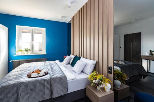 a bedroom with a large bed with blue walls at Willa Sarbinowska in Poznań