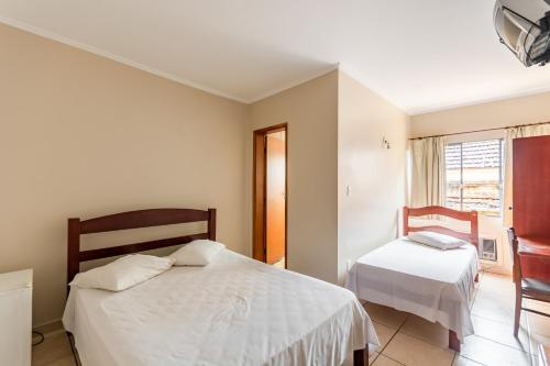 a bedroom with two beds and a window at OYO Hotel Vila Rica, Ribeirão Preto in Ribeirão Preto