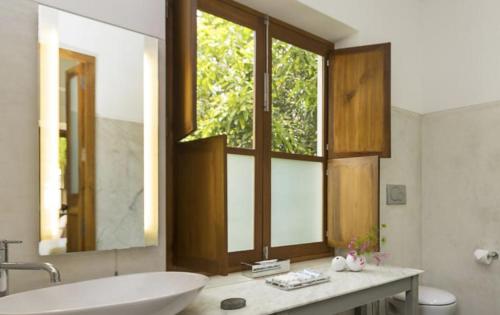 baño con bañera, lavabo y ventana en La Villa en Pondicherry