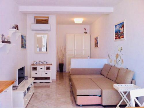 ein Wohnzimmer mit einem Sofa und einem TV in der Unterkunft “L’alcova delle Sirene” in Bergeggi