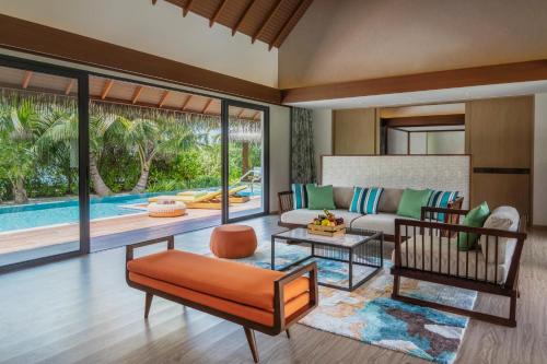 a living room with a couch and a table at Pullman Maldives Maamutaa - All-Inclusive Resort - 50 percent off Transfers in Maamutaa