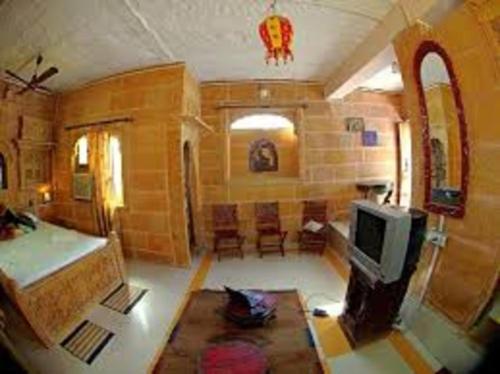 a living room with a bed and a tv at The Blue House in Jodhpur