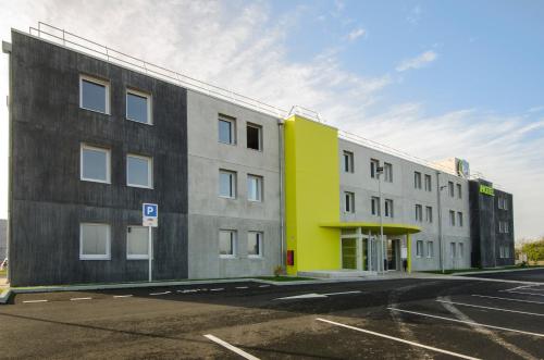 aartment building with a yellow and gray building at B&B HOTEL Montargis-Amilly in Amilly