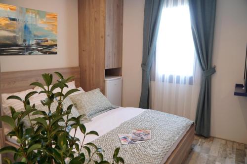 een slaapkamer met een bed, een plant en een raam bij Acropol Of Bodrum Beach Hotel in Ortakent