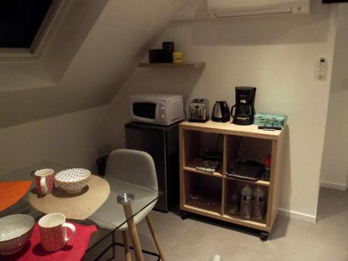 a small kitchen with a table and a microwave at L'Escapade Lochoise in Génillé