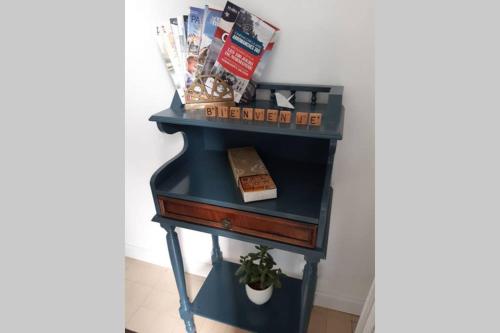 a blue table with a drawer and a shelf at La maison d'à côté in May-sur-Orne