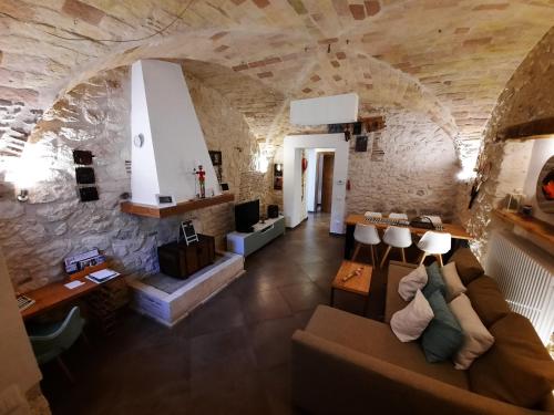 een woonkamer met een bank en een stenen muur bij Picchio&Pinocchio Guest House in Sulmona