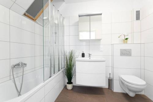 biała łazienka z toaletą i prysznicem w obiekcie Skyline Penthouse l LF44 w Wiedniu
